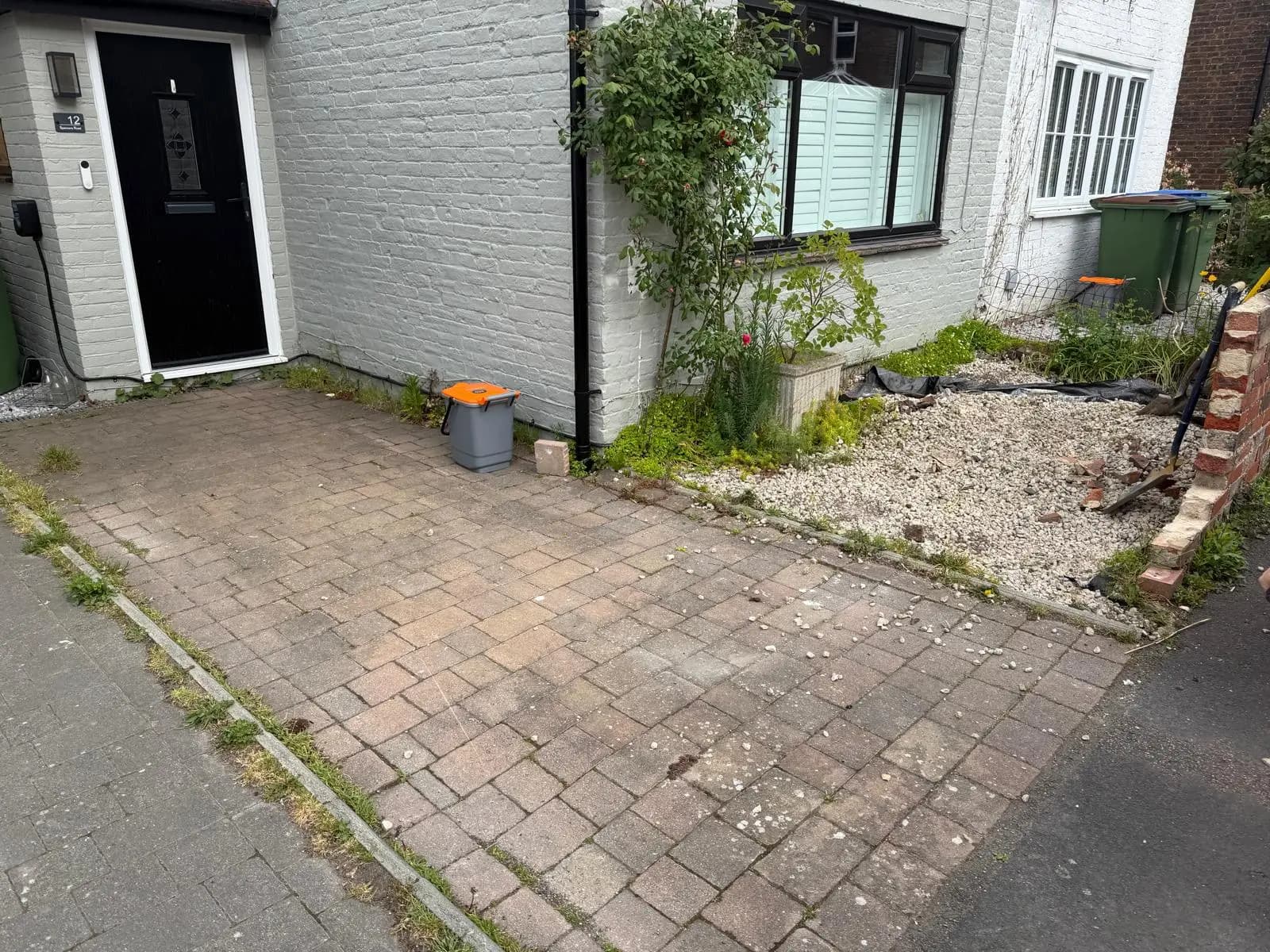 Old, faded and weed-grown block paving before the works