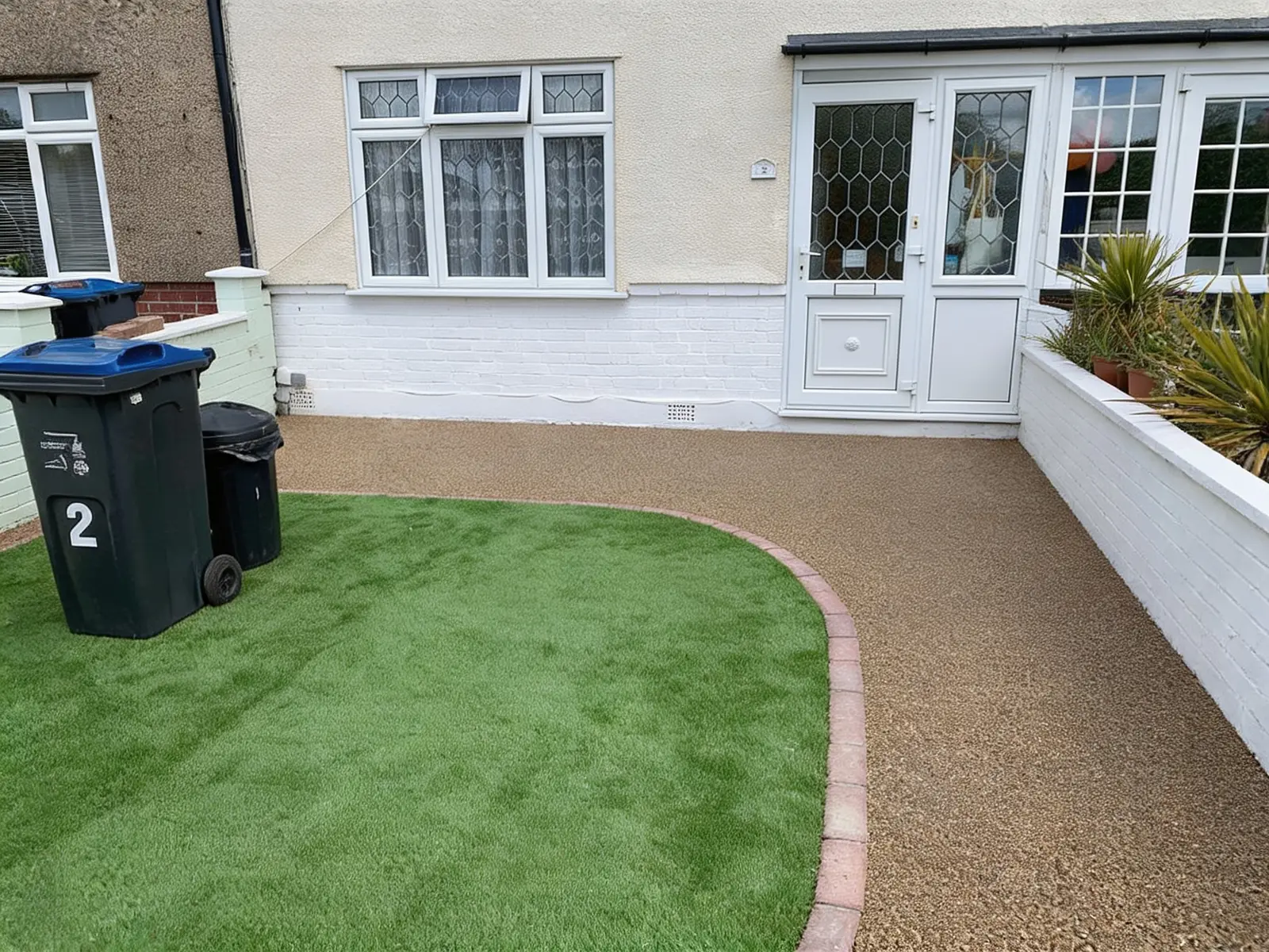 Finished resin driveway and curved artificial lawn at the front of the house