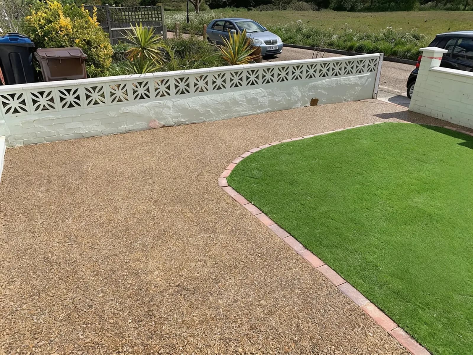 Finished gold resin-bound driveway with a curved brick-edged artificial lawn in Croydon