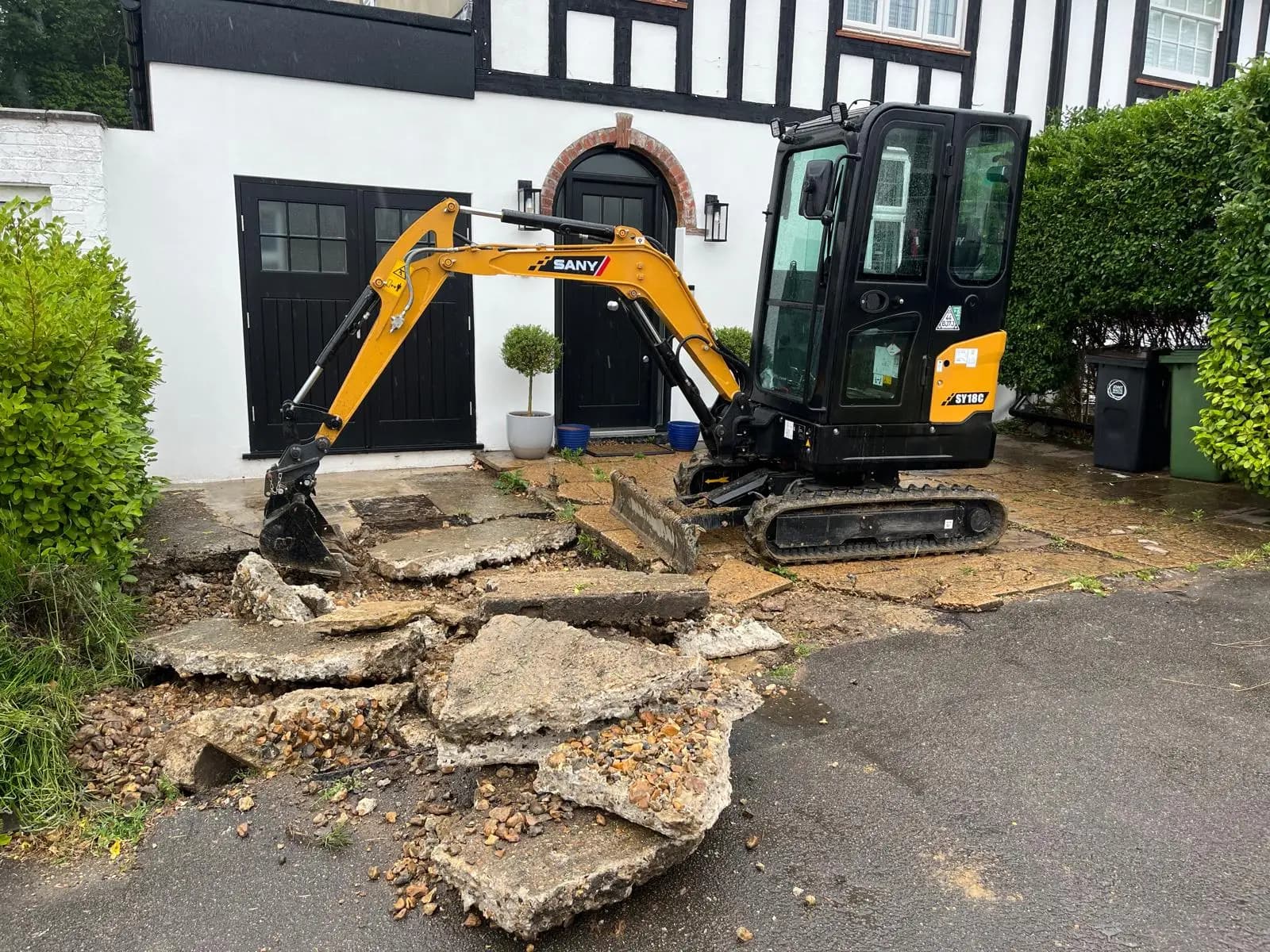 Cracked concrete driveway being broken out before the works