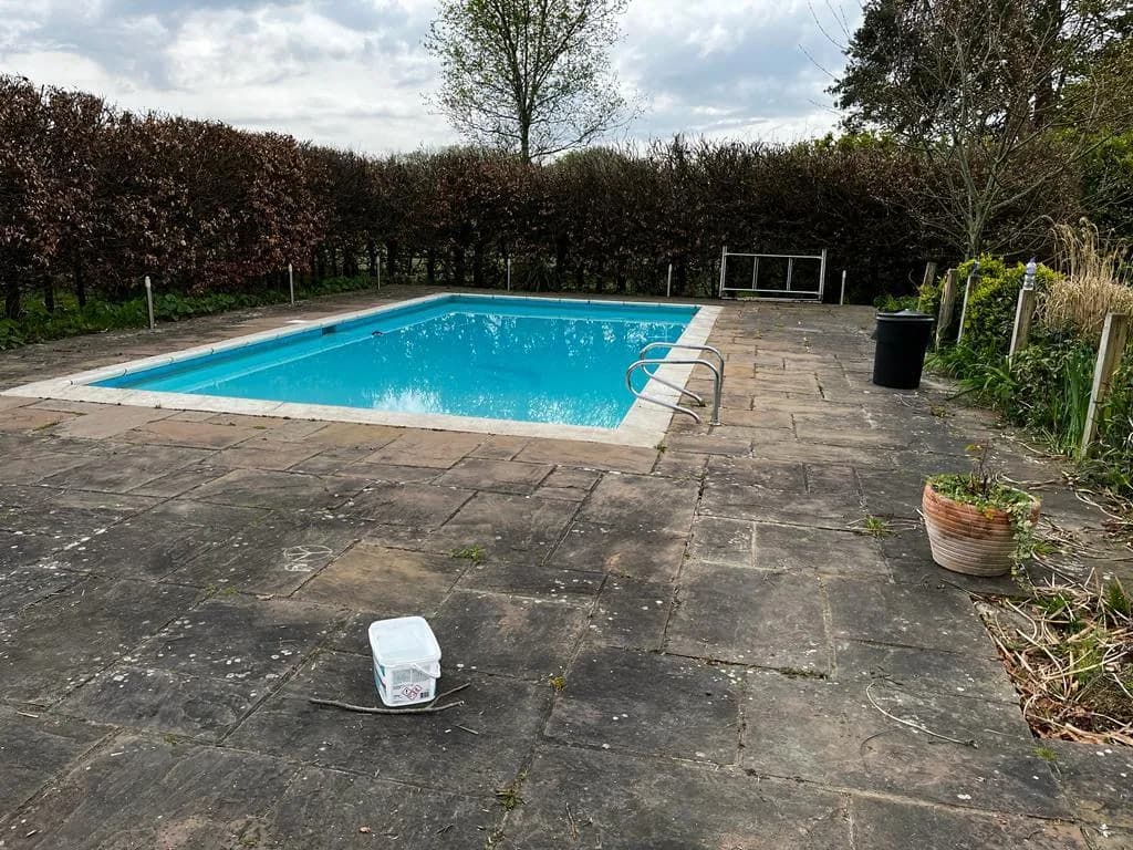 Tired concrete pool surround before resurfacing