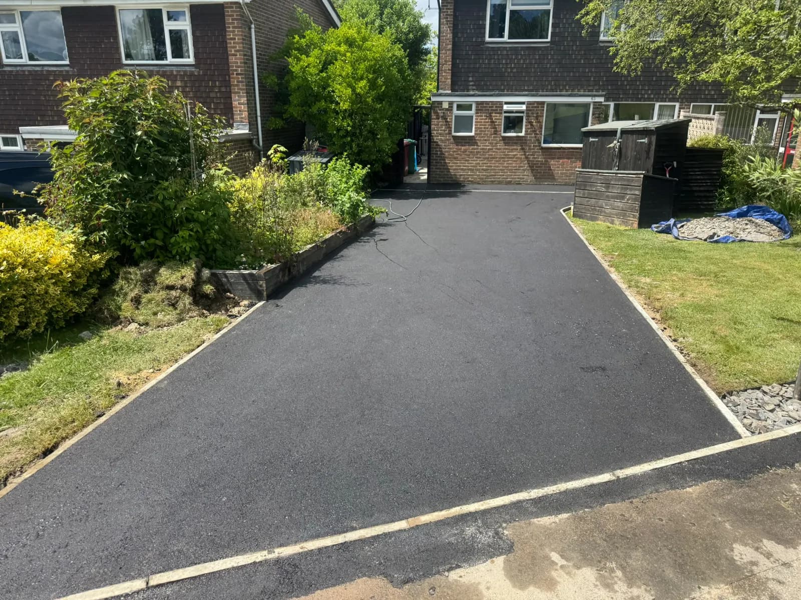 A finished tarmac driveway laid by Victory Surfacing, running up to a house in Surrey.