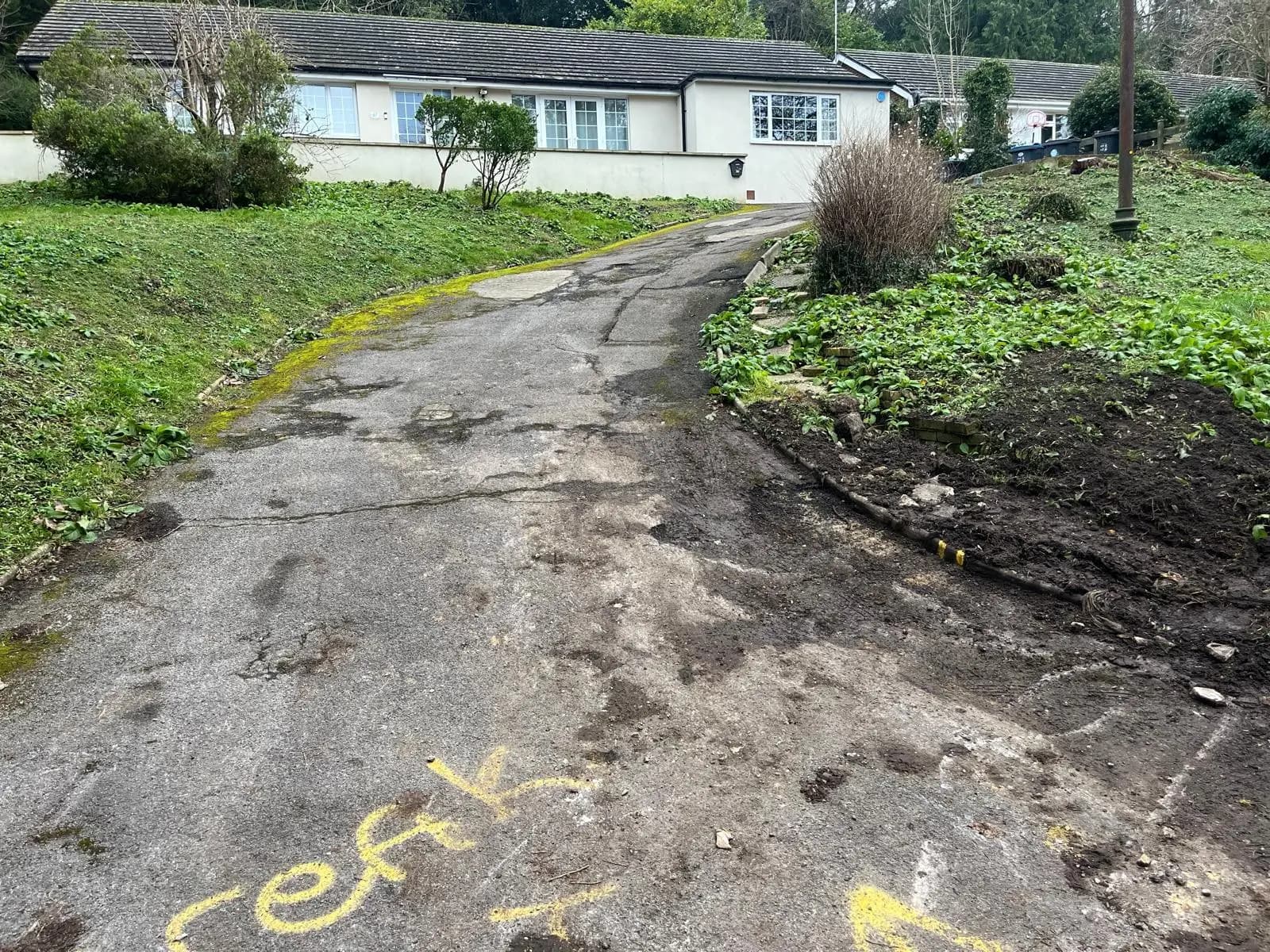 A cracked, broken-up tarmac surface in need of repair