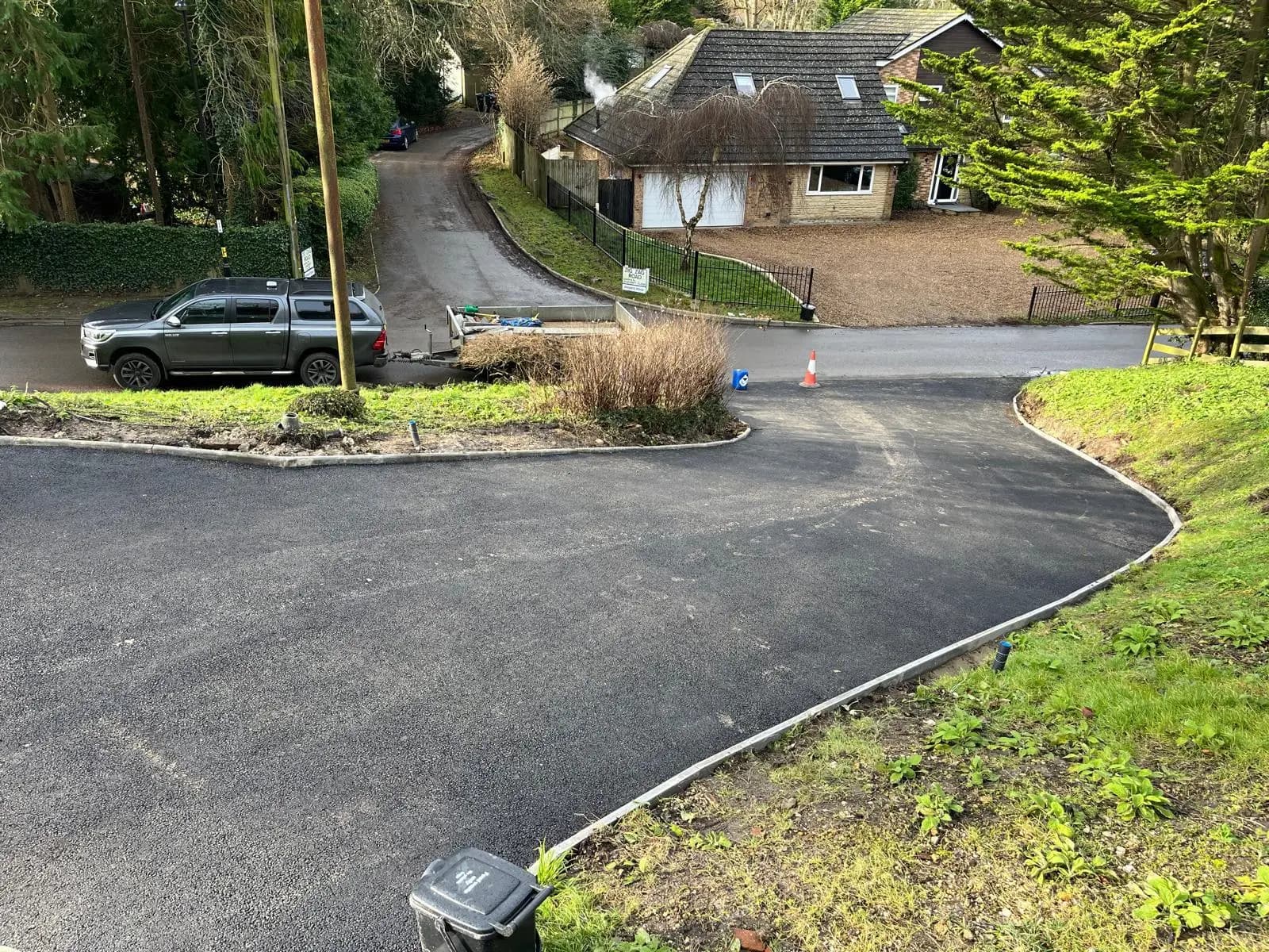 A smooth, hot-laid tarmac driveway sweeping up to a house