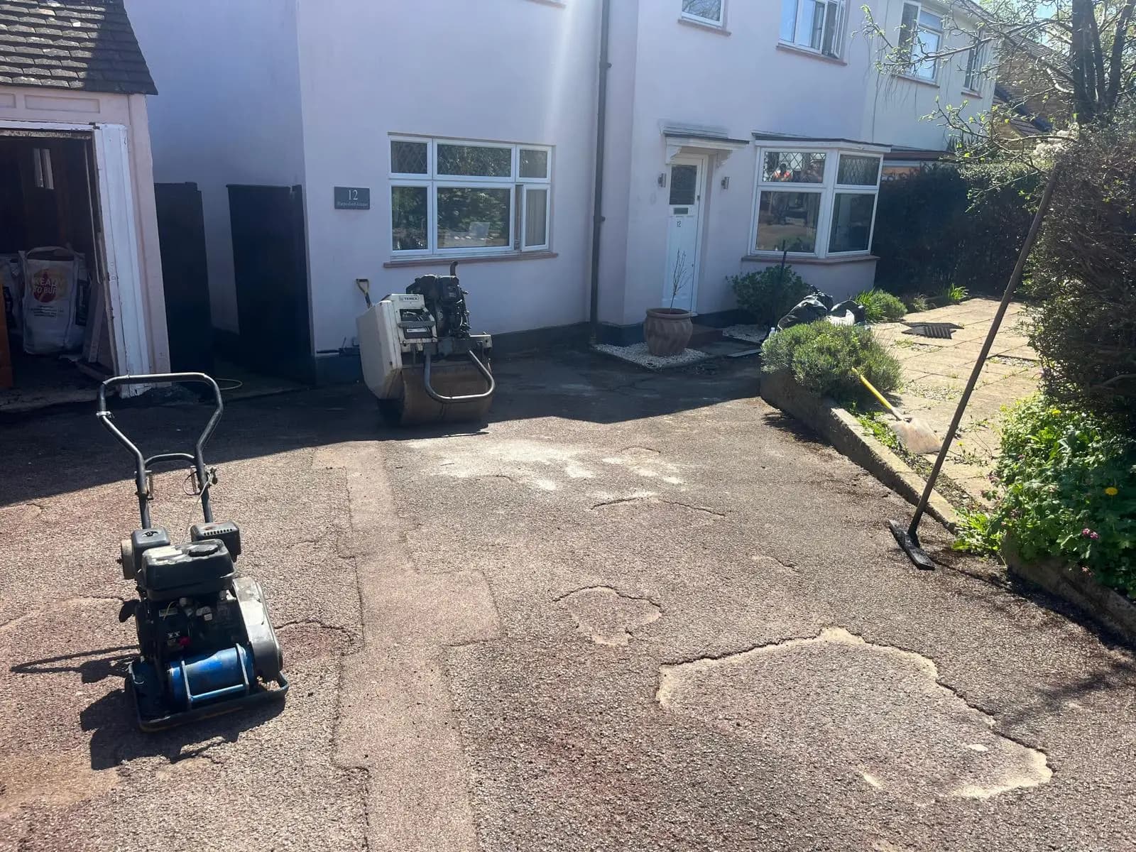 Worn, patched tarmac driveway before resurfacing